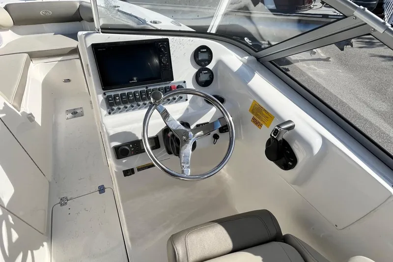 Slide: The Image of 2024 Key West 239 DFS boat dashboard with steering wheel and control panel. - 6
