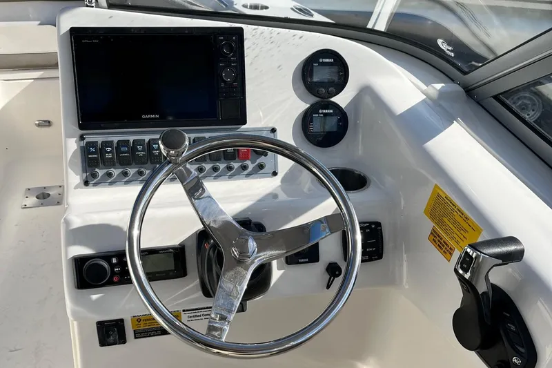Slide: The Image of 2024 Key West 239 DFS boat dashboard with steering wheel and electronic controls. - 7