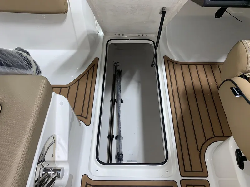 Slide: The Image of 2024 Bayliner VR5 boat interior storage compartment with brown and white flooring. - 4