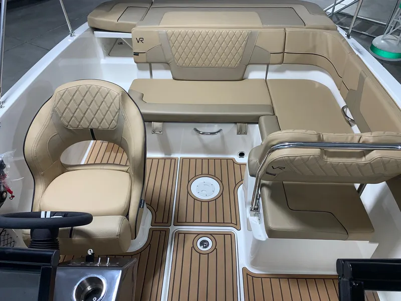 Slide: The Image of 2024 Bayliner VR5 boat interior with tan leather seating and teak flooring. - 12