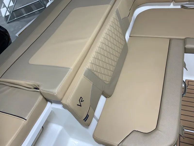 Slide: The Image of 2024 Bayliner VR5 boat with beige cushioned seating and diamond-stitched backrest. - 3