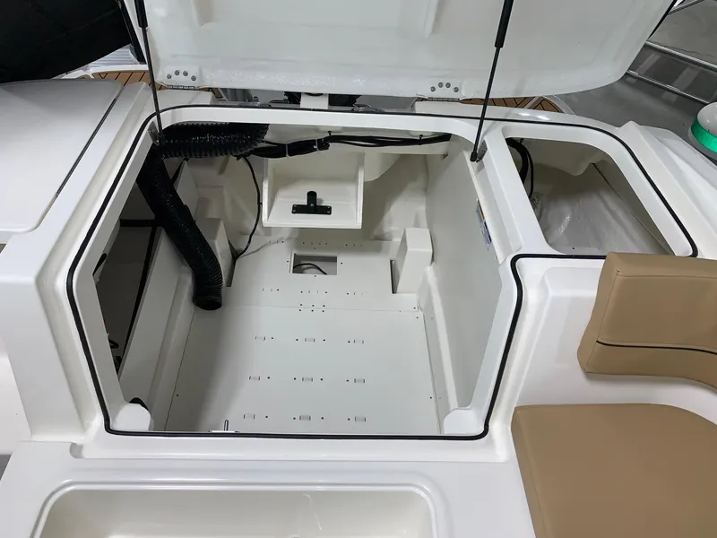 Slide: The Image of Open engine compartment of 2024 Bayliner VR5 boat with beige seating. - 6