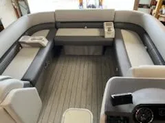 Slide: The Image of 2023 Sweetwater 2286SB pontoon boat interior with gray seating and wood-like flooring. - 10