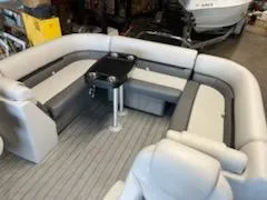 Slide: The Image of 2023 Sweetwater 2286SB pontoon boat interior with gray seating and a central table. - 13