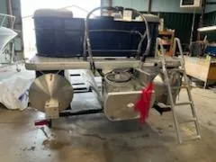 Slide: The Image of 2023 Sweetwater 2286SB pontoon boat in a workshop, rear view with ladder. - 7