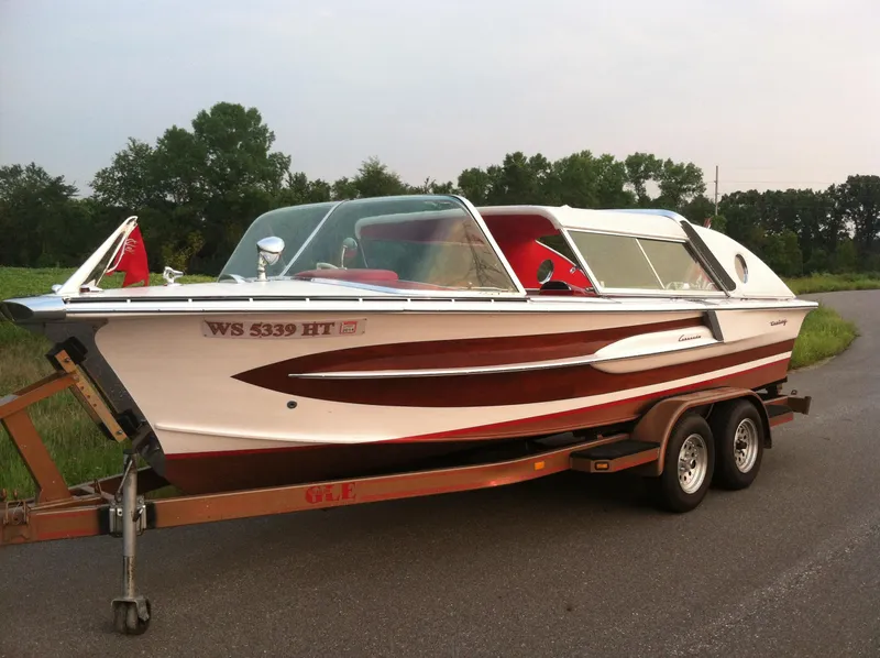 Slide: The Image of 1959 Century Coronado boat on trailer, white and red design, parked on road. - 11