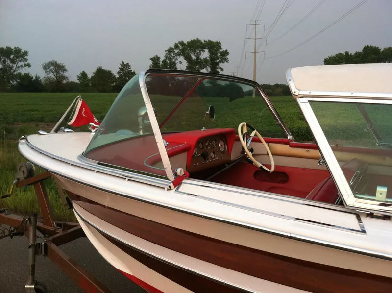 Slide: The Image of 1959 Century Coronado boat with red interior and classic design on a trailer. - 12