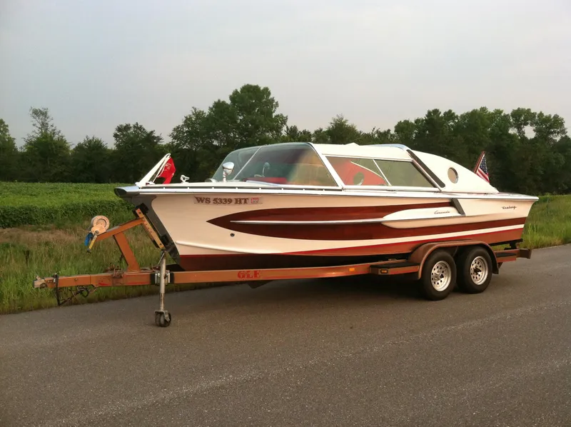 Slide: The Image of 1959 Century Coronado boat on trailer, parked on roadside with trees in background. - 7