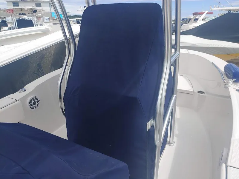 Slide: The Image of 2022 Robalo R180 Center Console boat interior with blue seat covers and stainless steel railings. - 12