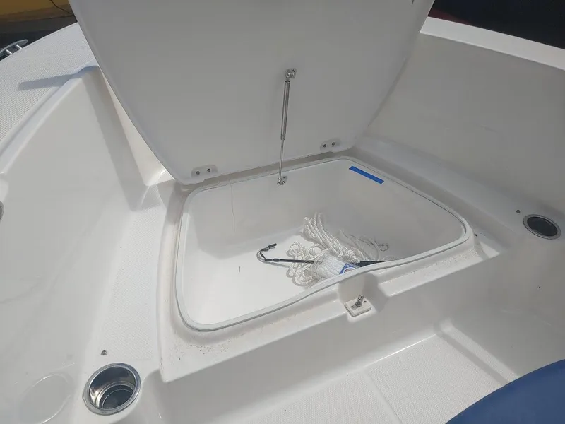 Slide: The Image of 2022 Robalo R180 Center Console boat storage compartment open, showing interior details. - 21