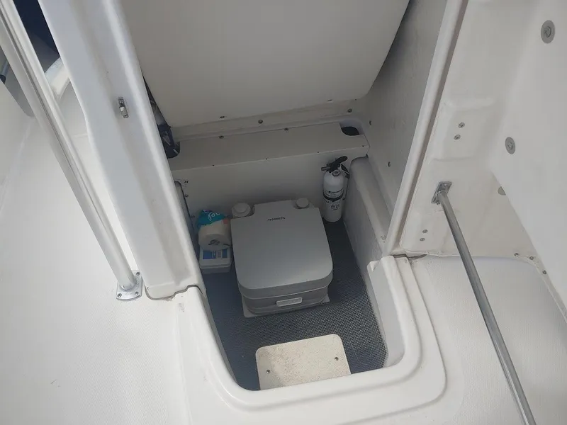 Slide: The Image of 2022 Robalo R180 Center Console boat storage compartment with portable toilet. - 23