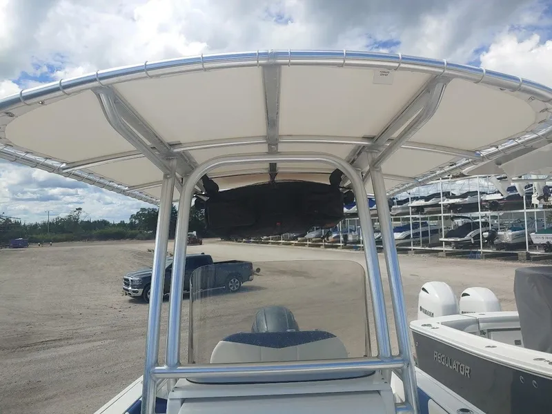 Slide: The Image of 2022 Robalo R180 Center Console boat with T-top, parked outdoors under cloudy sky. - 26
