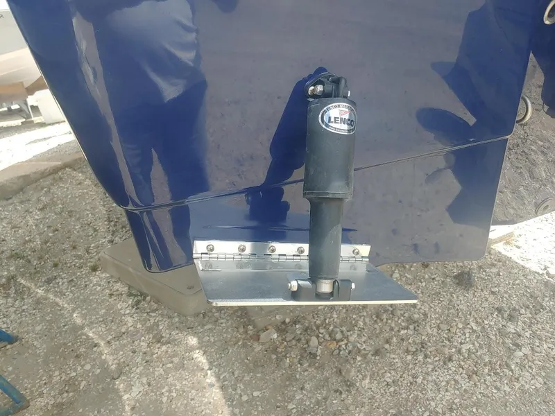 Slide: The Image of 2022 Robalo R180 Center Console boat with trim tab detail. - 5