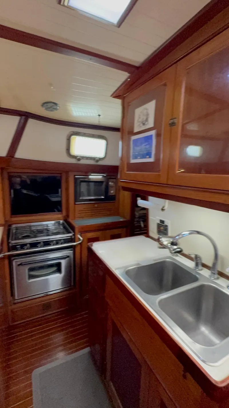 Slide: The Image of Interior of 1984 Shannon Aegean 51 yacht kitchen with wooden cabinets and stainless steel appliances. - 11