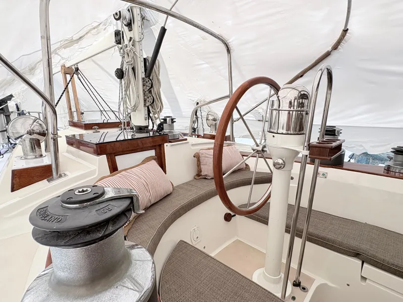 Slide: The Image of 1984 Shannon Aegean 51 yacht cockpit with wooden wheel and cushioned seating. - 32
