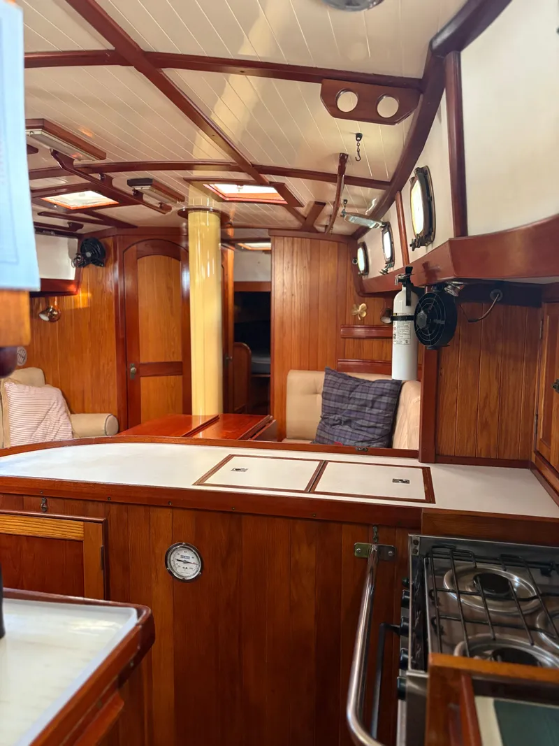Slide: The Image of Interior of 1984 Shannon Aegean 51 sailboat with wooden furnishings and cozy seating. - 8