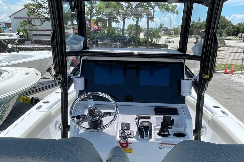 Slide: The Image of 2022 Sportsman Masters 267OE Bay Boat dashboard with steering wheel and controls. - 10