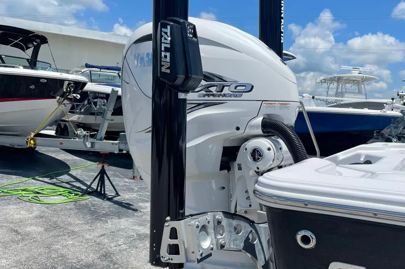 Slide: The Image of 2022 Sportsman Masters 267OE Bay Boat with powerful outboard motor in marina setting. - 4