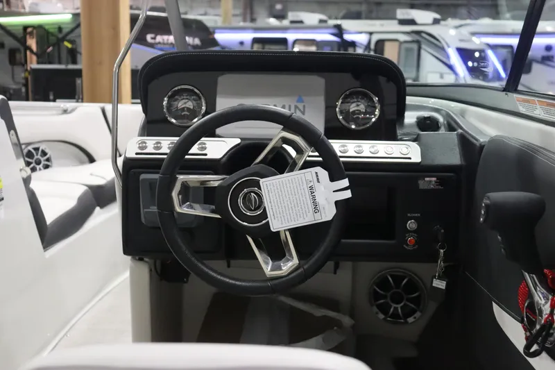 Slide: The Image of 2023 Crownline 240SS boat dashboard with steering wheel and control panel. - 9