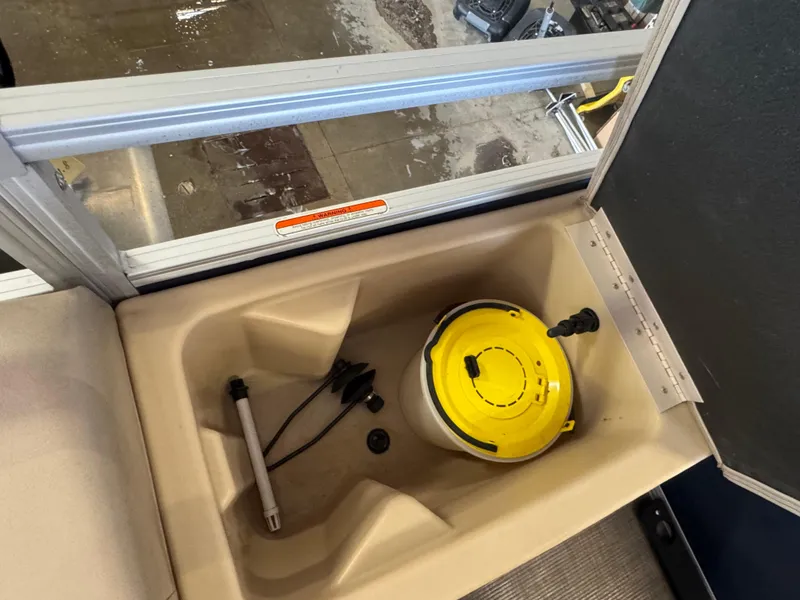 Slide: The Image of 2019 Sun Tracker SportFish 22 DLX storage compartment with yellow lid and accessories. - 16