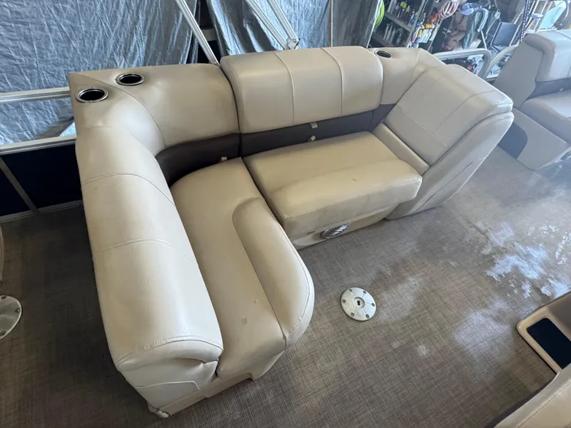 Slide: The Image of 2019 Sun Tracker SportFish 22 DLX boat interior with beige seating and cup holders. - 17
