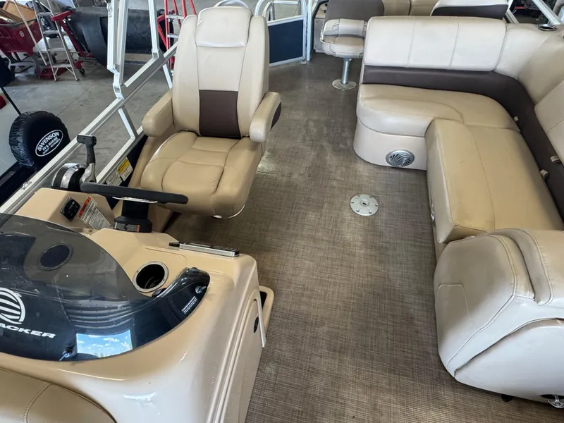 Slide: The Image of 2019 Sun Tracker SportFish 22 DLX interior with beige seating and steering console. - 8