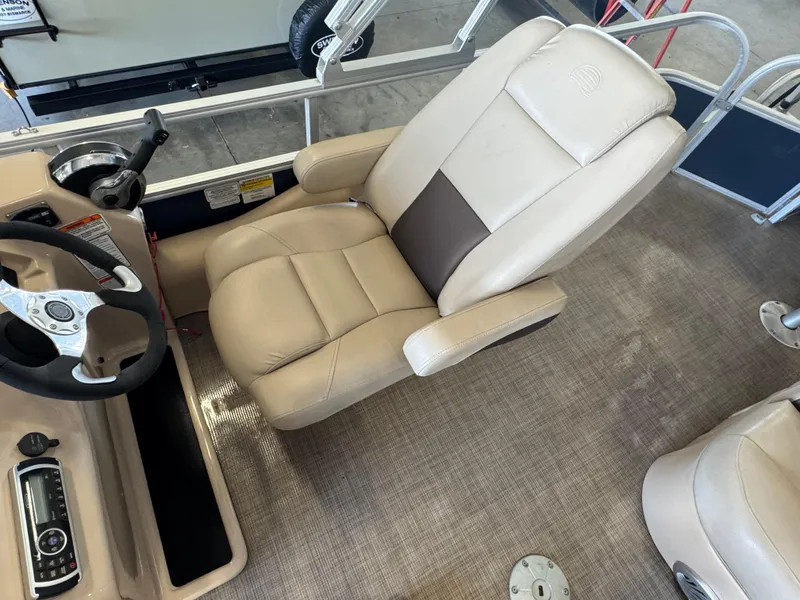 Slide: The Image of 2019 Sun Tracker SportFish 22 DLX boat interior with beige captain's chair and steering console. - 9