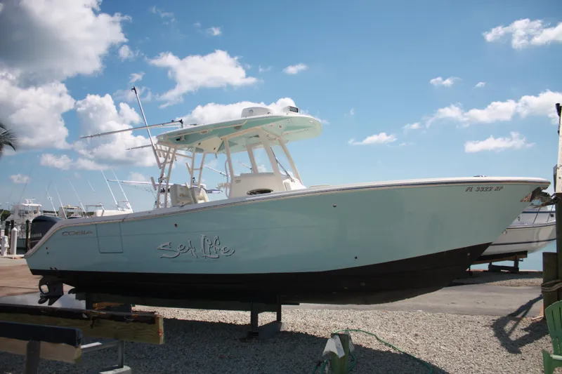 The Image of 2018 Cobia 301 Center Console auf einem Bootsanhänger, bereit für Abenteuer. - 0