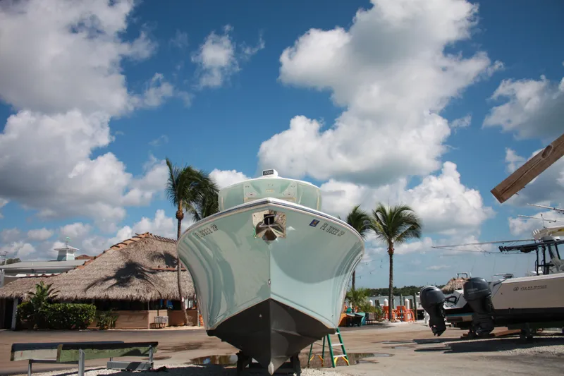 Slide: The Image of Ein Cobia 301 Center Console Boot von 2018 steht an Land unter einem blauen Himmel mit Wolken. - 5
