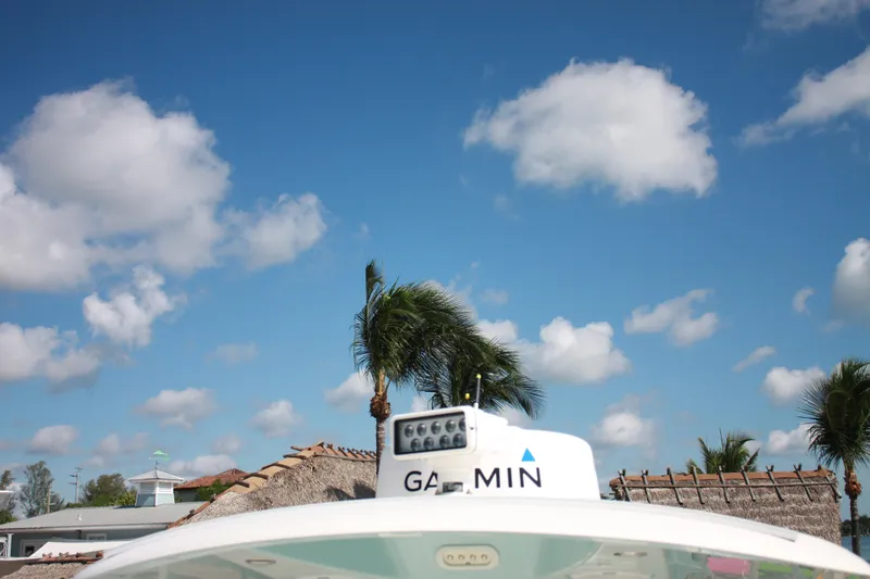 Slide: The Image of Ein Garmin-Radar auf einem Boot vor einem blauen Himmel mit Wolken und Palmen. - 31