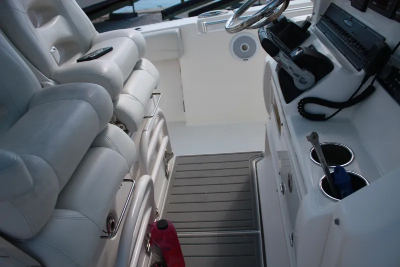 Slide: The Image of Das Bild zeigt das Cockpit eines Cobia 301 Center Console Bootes von 2018 mit weißen Sitzen und Steuerkonsole. - 15