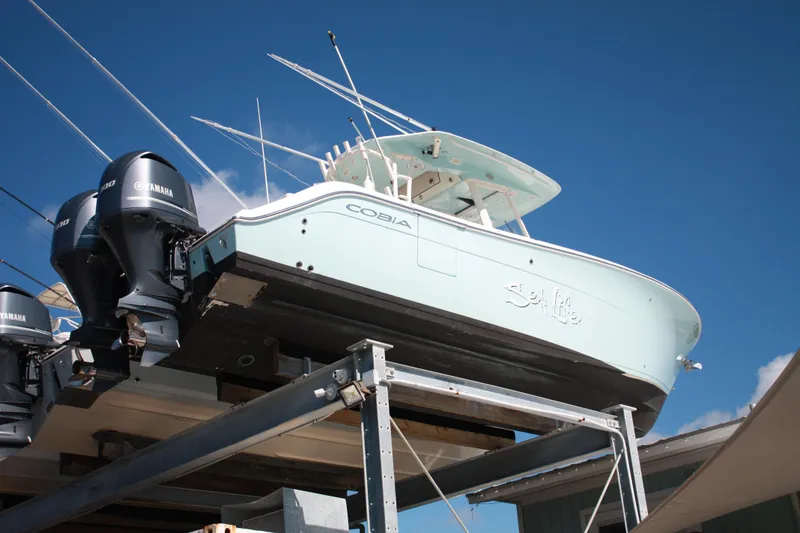 Slide: The Image of Ein Cobia 301 Center Console Boot von 2018 auf einem Bootslift mit zwei Außenbordmotoren. - 7