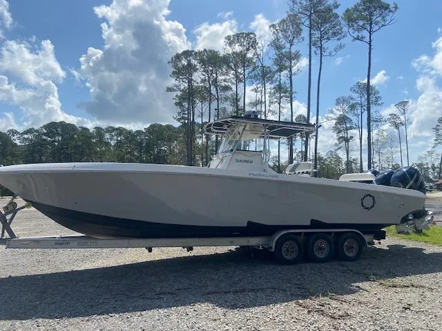 Slide: The Image of 2004 Fountain 34 CC boat on a triple-axle trailer, parked outdoors. - 1
