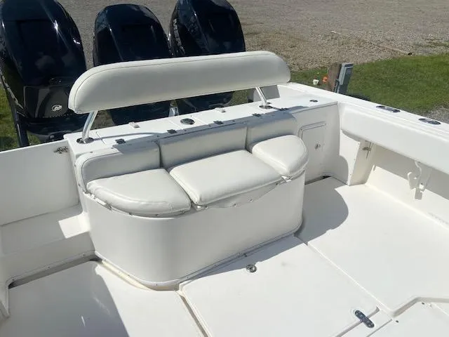 Slide: The Image of 2004 Fountain 34 CC boat with white cushioned seating and triple outboard motors. - 13