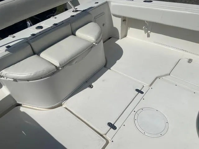 Slide: The Image of 2004 Fountain 34 CC boat interior with white cushioned seating and storage compartments. - 14