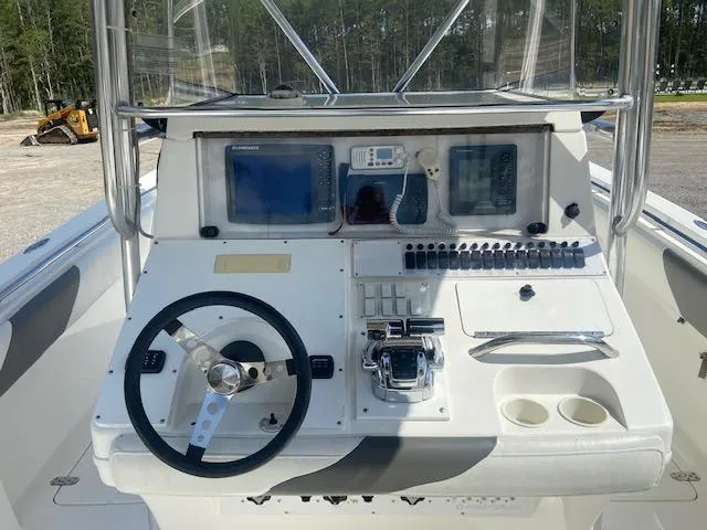 Slide: The Image of 2004 Fountain 34 CC boat dashboard with steering wheel, controls, and navigation screens. - 16