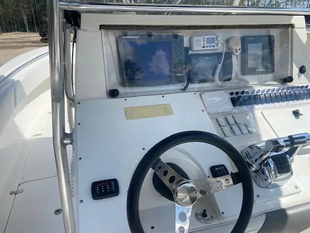 Slide: The Image of 2004 Fountain 34 CC boat dashboard with steering wheel and navigation equipment. - 18