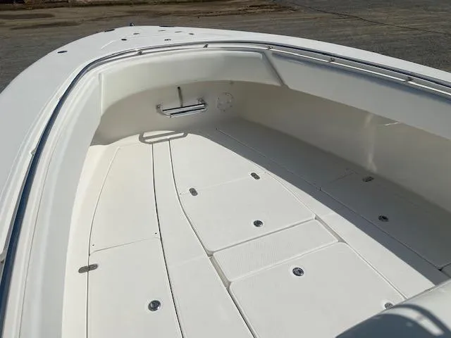 Slide: The Image of 2004 Fountain 34 CC boat interior, spacious white deck with storage compartments. - 19