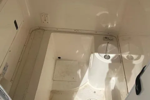 Slide: The Image of Interior of a 2004 Fountain 34 CC boat showing a clean, white compartment. - 27