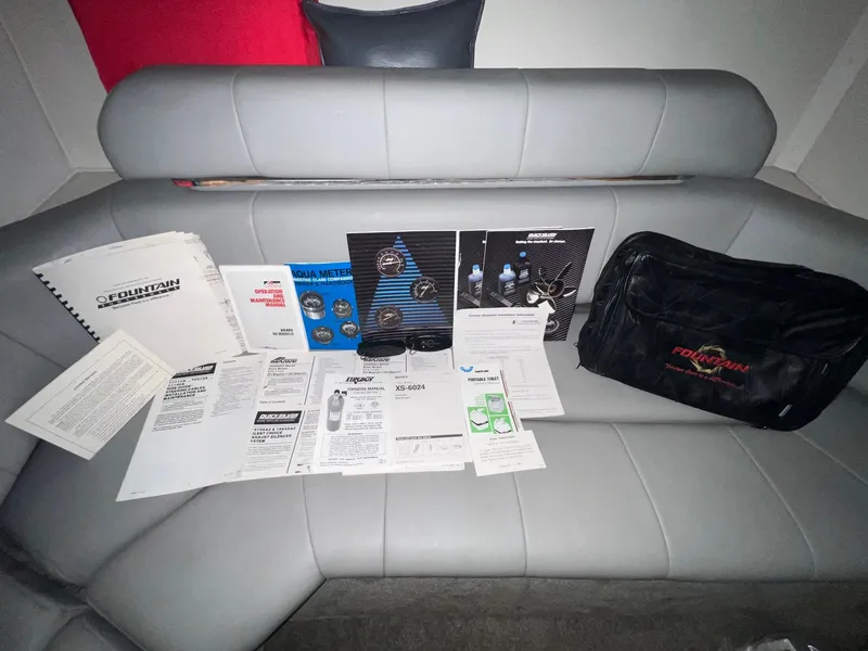 Slide: The Image of 1992 Fountain 42 Lightning manuals and accessories on a gray boat seat. - 21