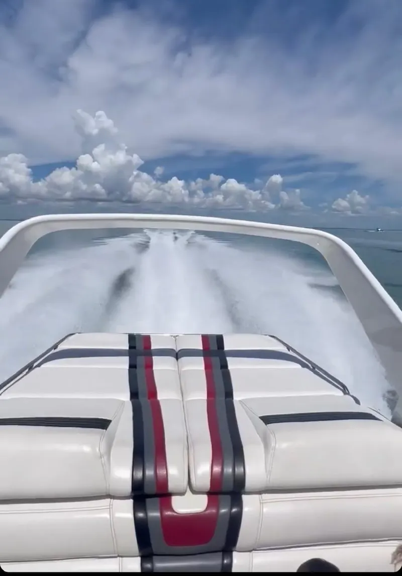 Slide: The Image of 1992 Fountain 42 Lightning speedboat on water, leaving a wake under a clear sky. - 8