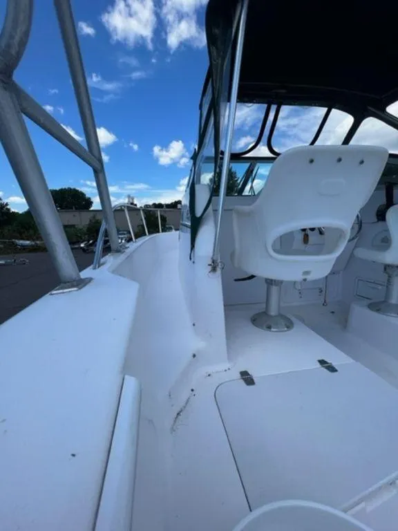 Slide: The Image of 2001 Pro-Line 25 Walkaround boat interior with white seating and clear blue sky. - 11