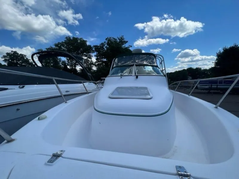Slide: The Image of 2001 Pro-Line 25 Walkaround boat under a blue sky with clouds. - 16