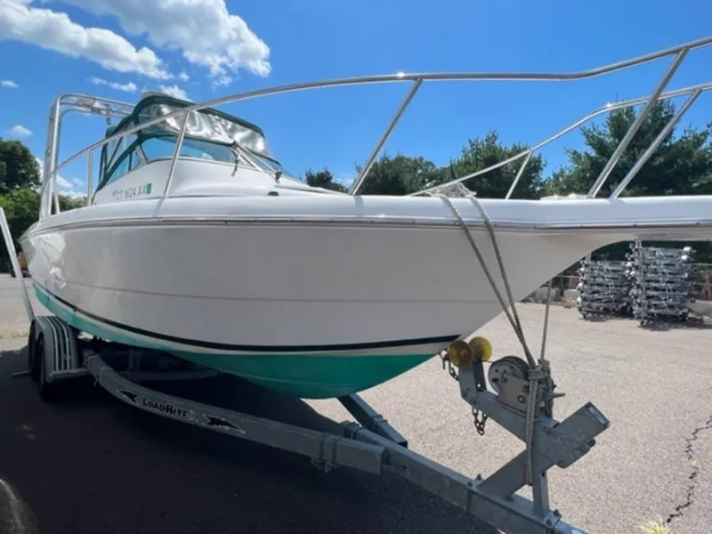 Slide: The Image of 2001 Pro-Line 25 Walkaround boat on trailer under blue sky. - 3