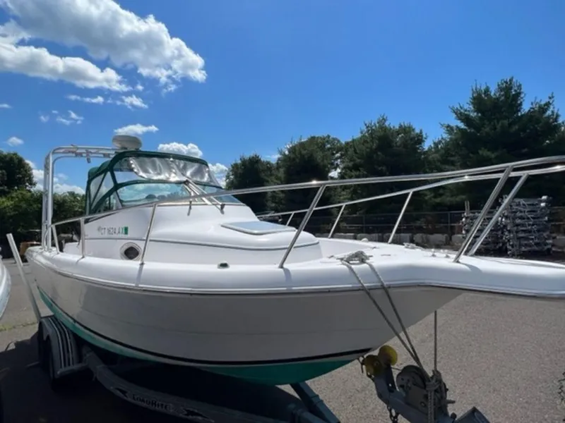 Slide: The Image of 2001 Pro-Line 25 Walkaround boat on trailer under blue sky. - 4