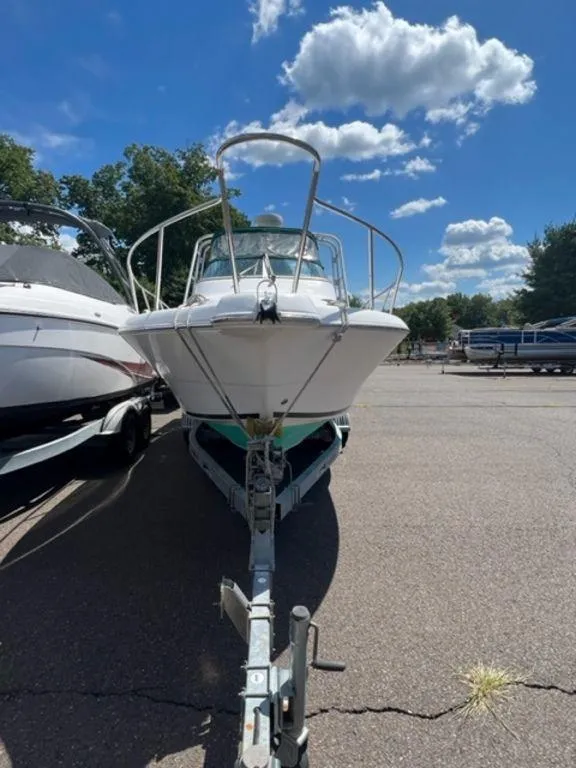 Slide: The Image of 2001 Pro-Line 25 Walkaround boat on trailer under a clear blue sky. - 5