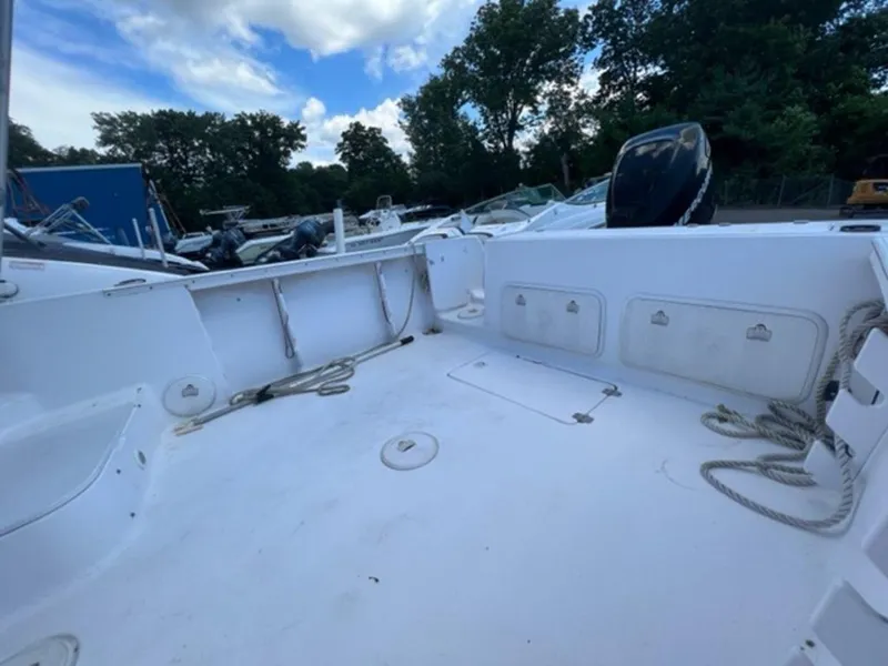 Slide: The Image of 2001 Pro-Line 25 Walkaround boat deck with storage compartments and ropes. - 7