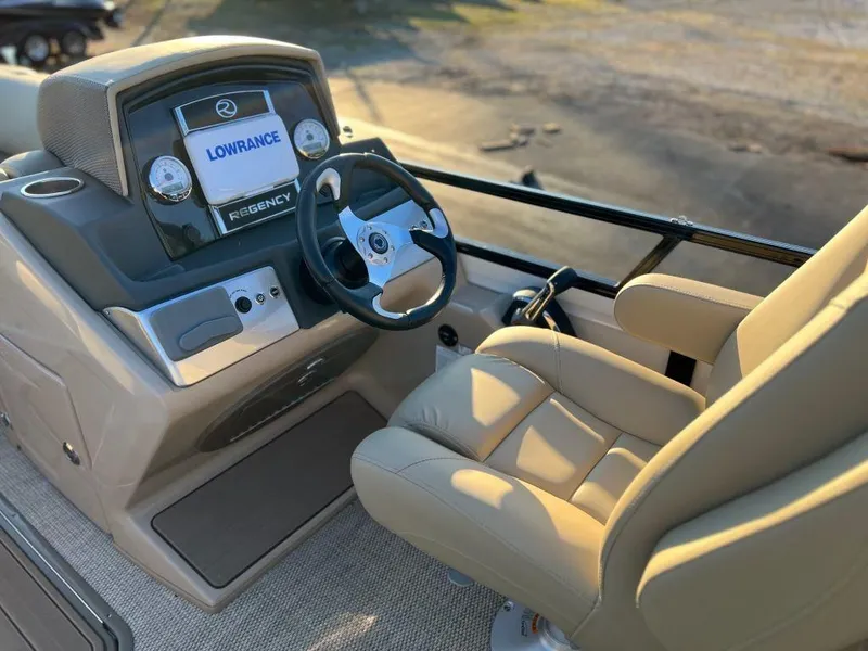 Slide: The Image of 2023 Regency 230 DL3 boat helm with Lowrance display and beige captain's chair. - 3