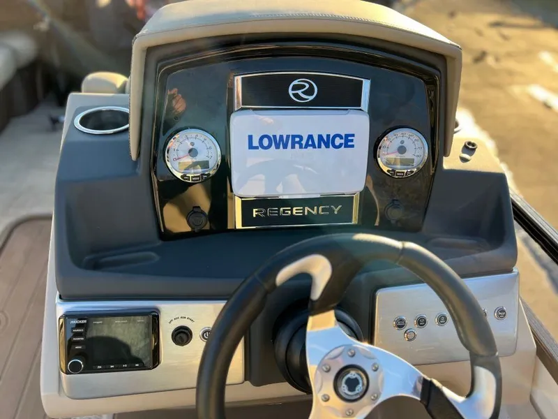 Slide: The Image of 2023 Regency 230 DL3 boat dashboard with Lowrance display and steering wheel. - 7