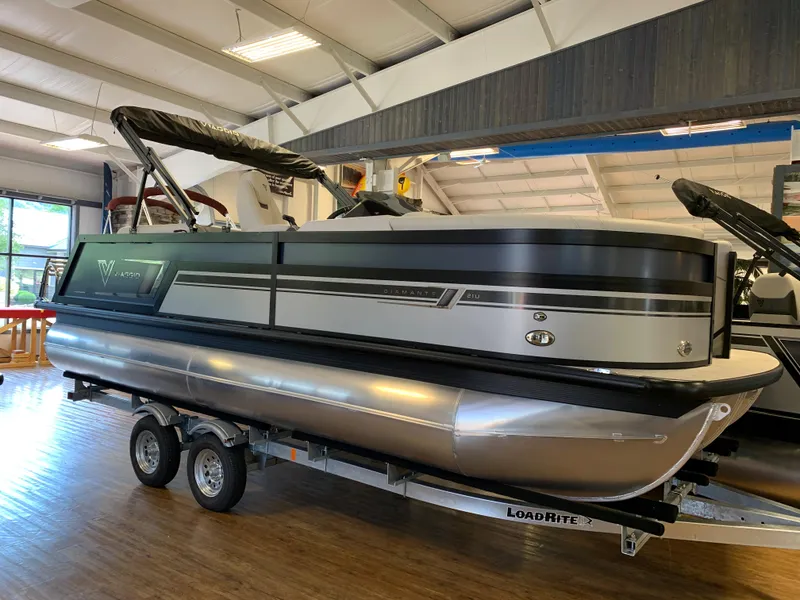 The Image of 2023 Viaggio Diamante 21U pontoon boat on a Load Rite trailer in a showroom. - 1